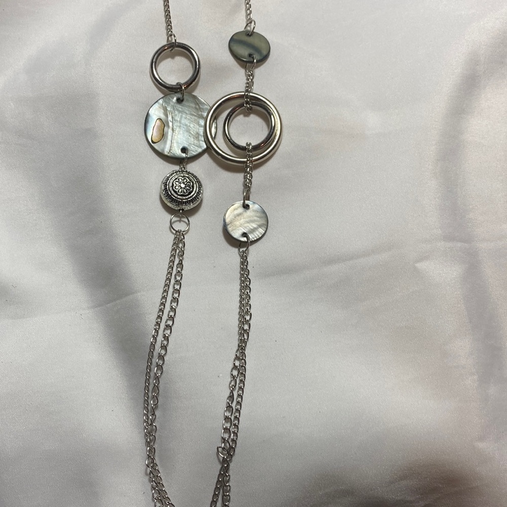 Long silver necklace with abalone accent pieces.